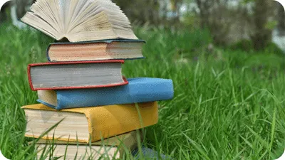 Books outside sitting in a grassy area