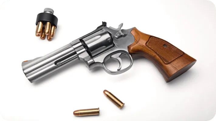 Stainless Revolver handgun with bullets and a speedloader