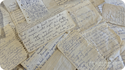 handwritten recipes spread out on a table