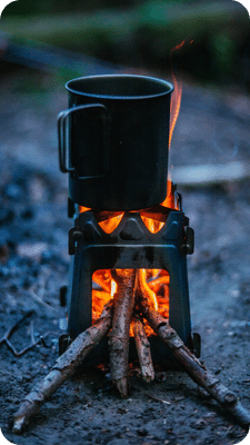Survival stove burning with a container on top