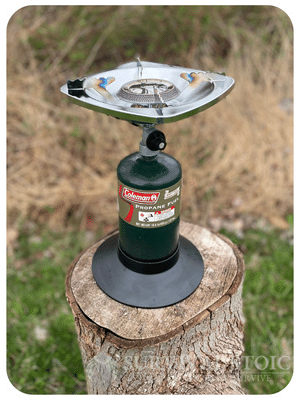 Bottle Top Stove outside on a stump