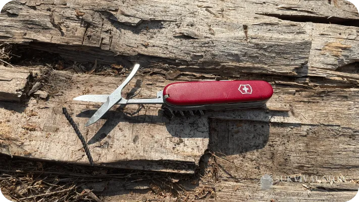 Swiss Army Knife scissors shown open cutting a piece of cordage