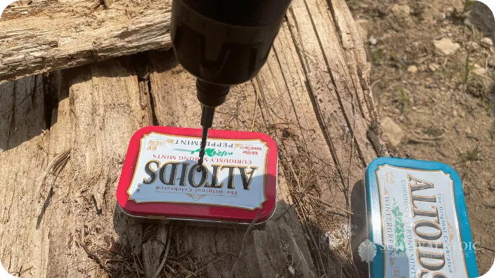 The author drilling a hold in an altoids tin