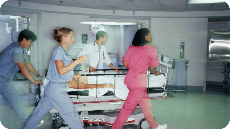 Patient in the Hospital on a bed with Doctors