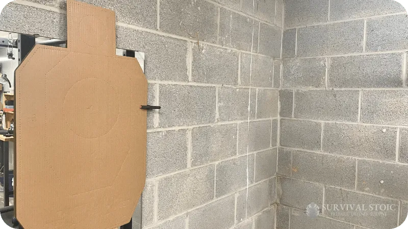 Jason's dry fire area showing a cardboard target hanging on a concrete block basement wall